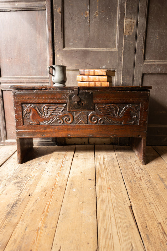 An  Elizabethan carved oak boarded chest with winged fantastic beasts, english, probably West Country, circa 1570–90