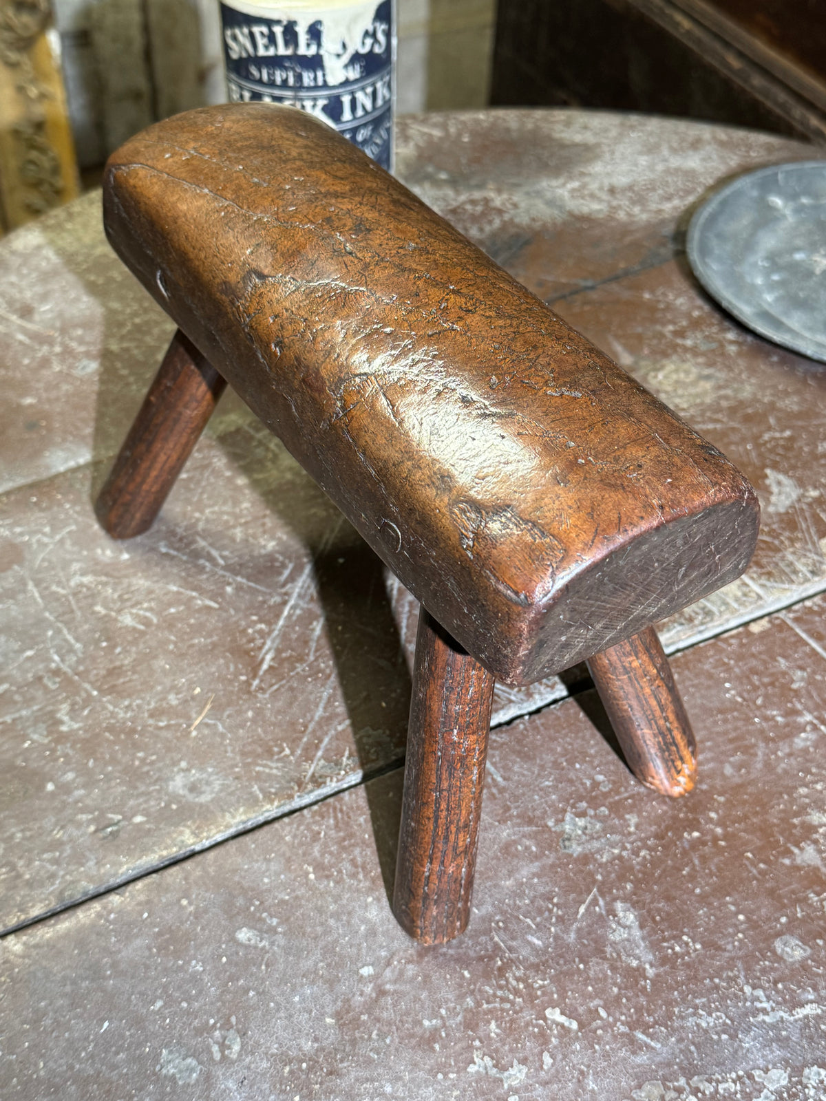 An unusual diminutive vernacular stool with sculpted rounded seat c.1800