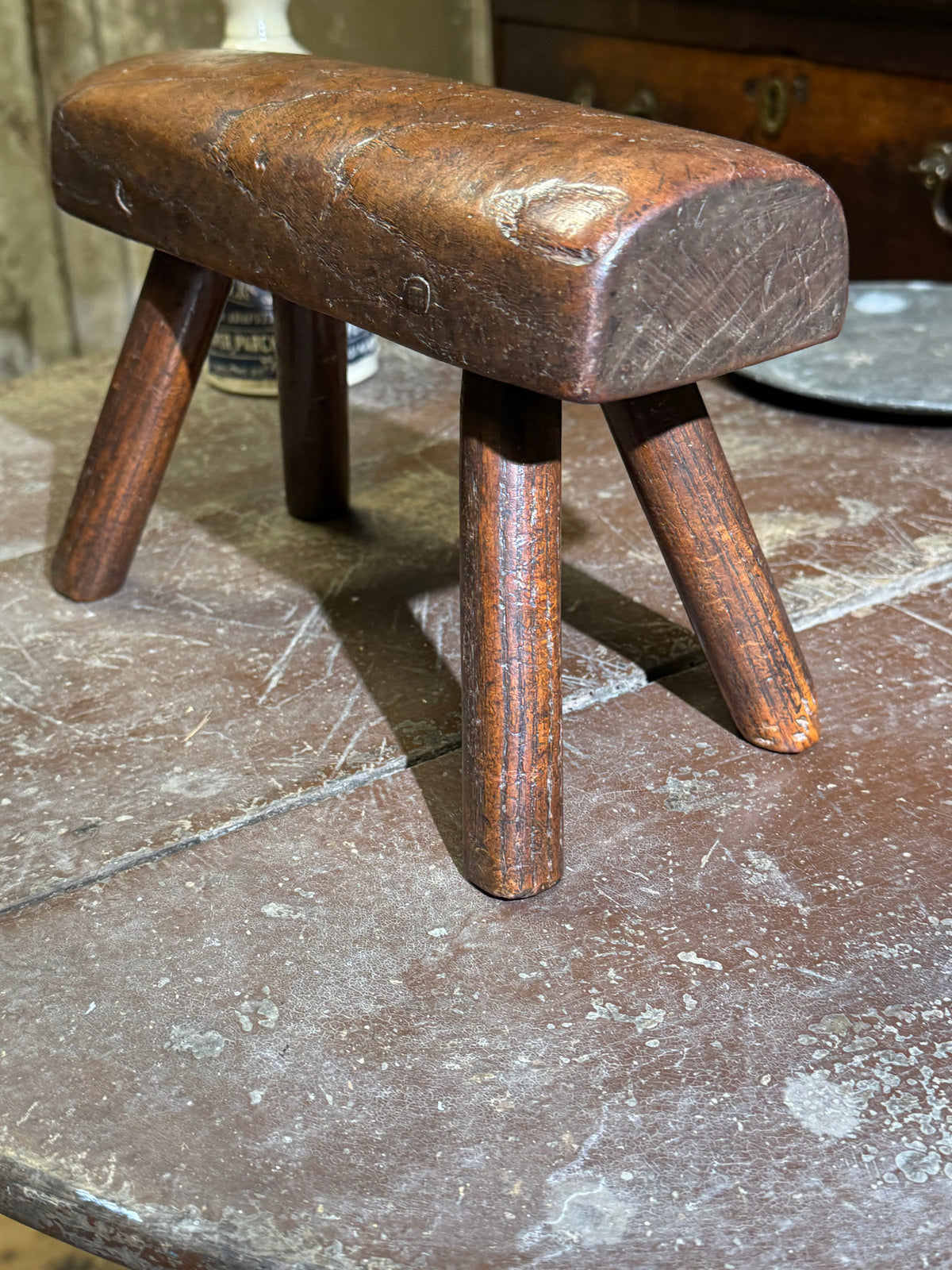 An unusual diminutive vernacular stool with sculpted rounded seat c.1800