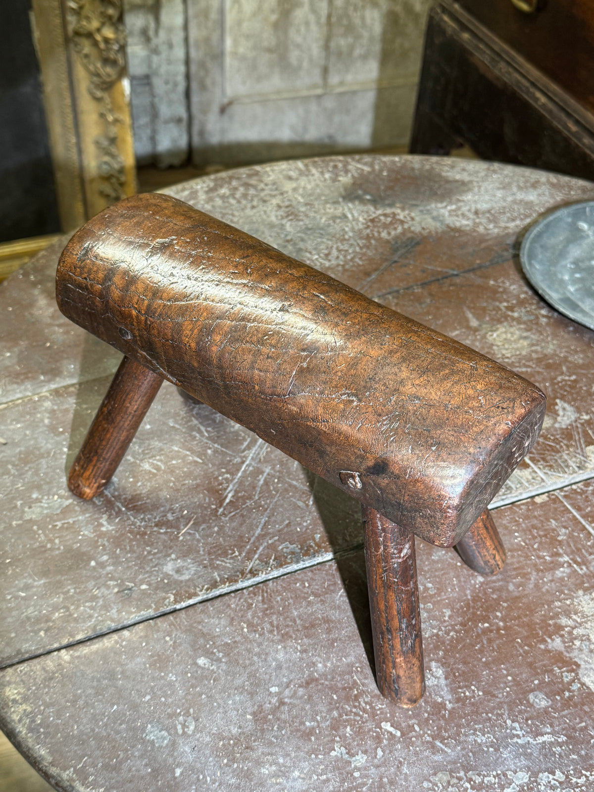 An unusual diminutive vernacular stool with sculpted rounded seat c.1800