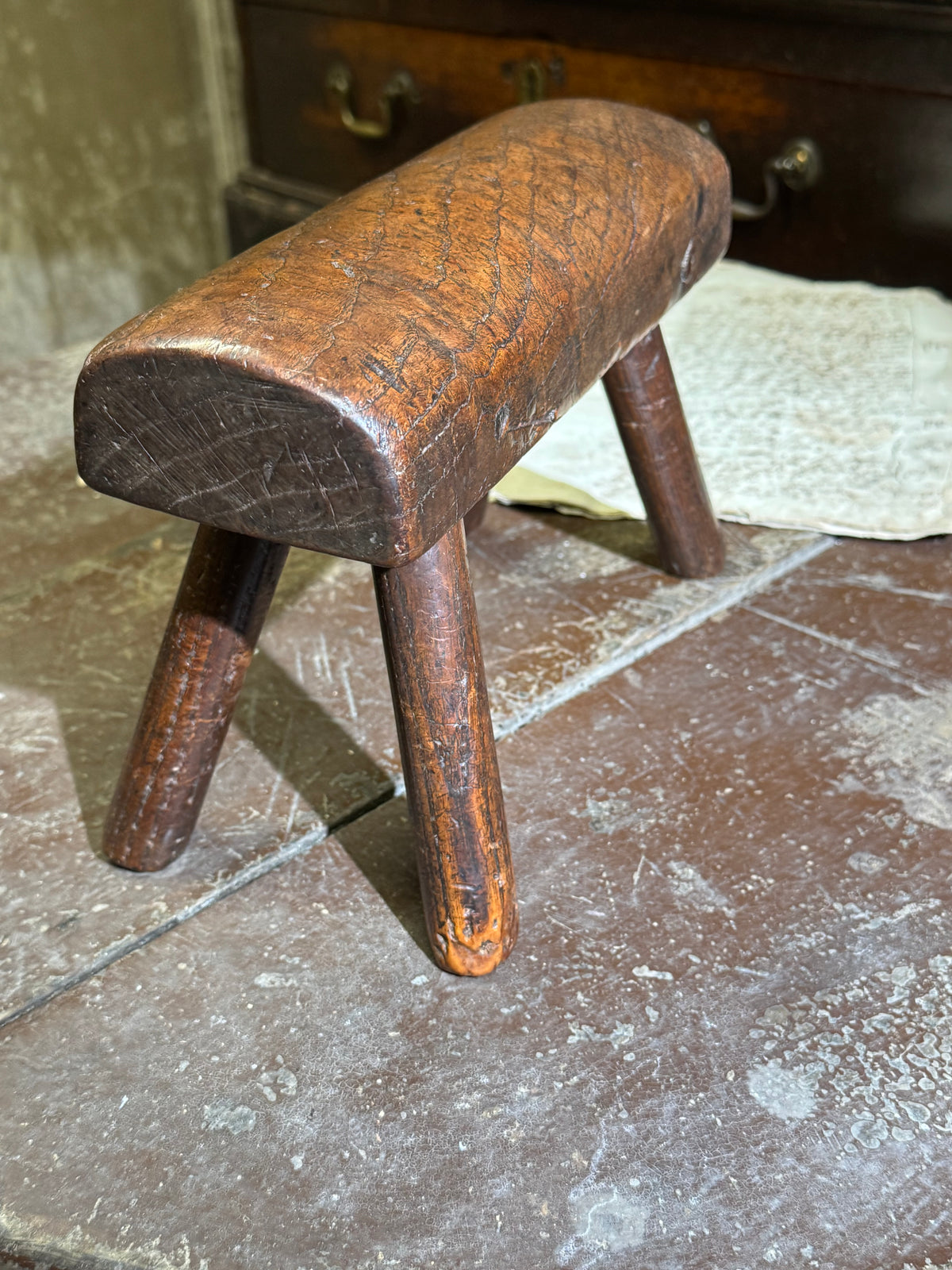 An unusual diminutive vernacular stool with sculpted rounded seat c.1800