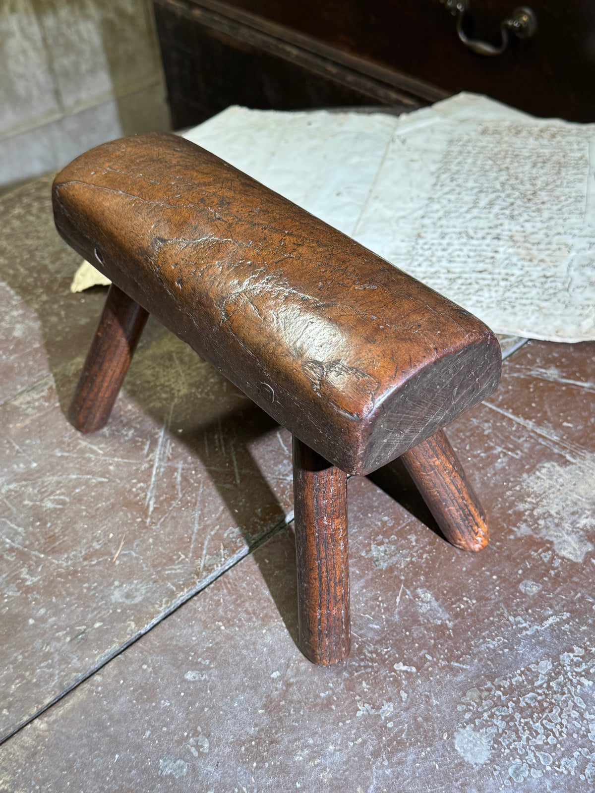 An unusual diminutive vernacular stool with sculpted rounded seat c.1800