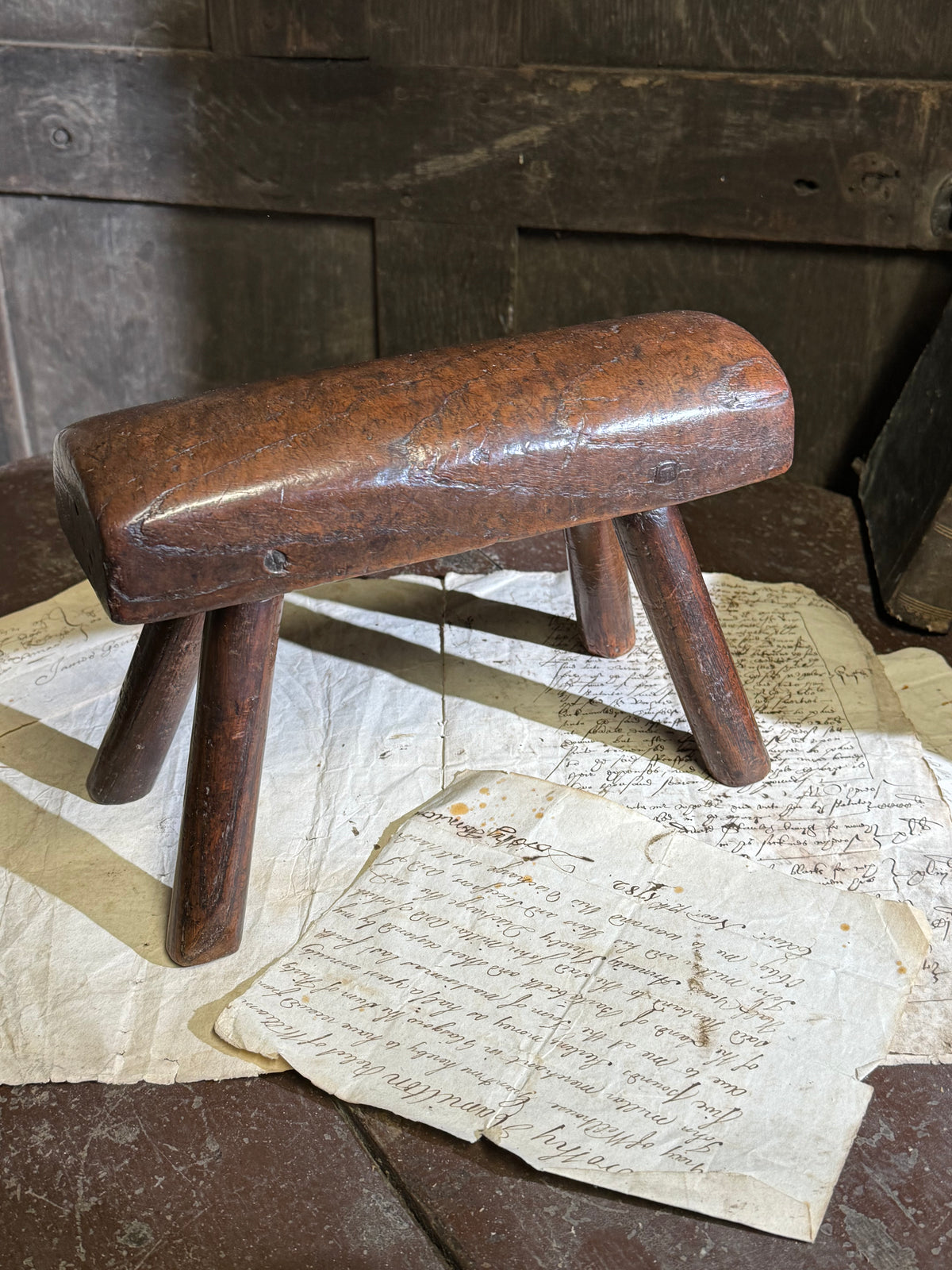 An unusual diminutive vernacular stool with sculpted rounded seat c.1800
