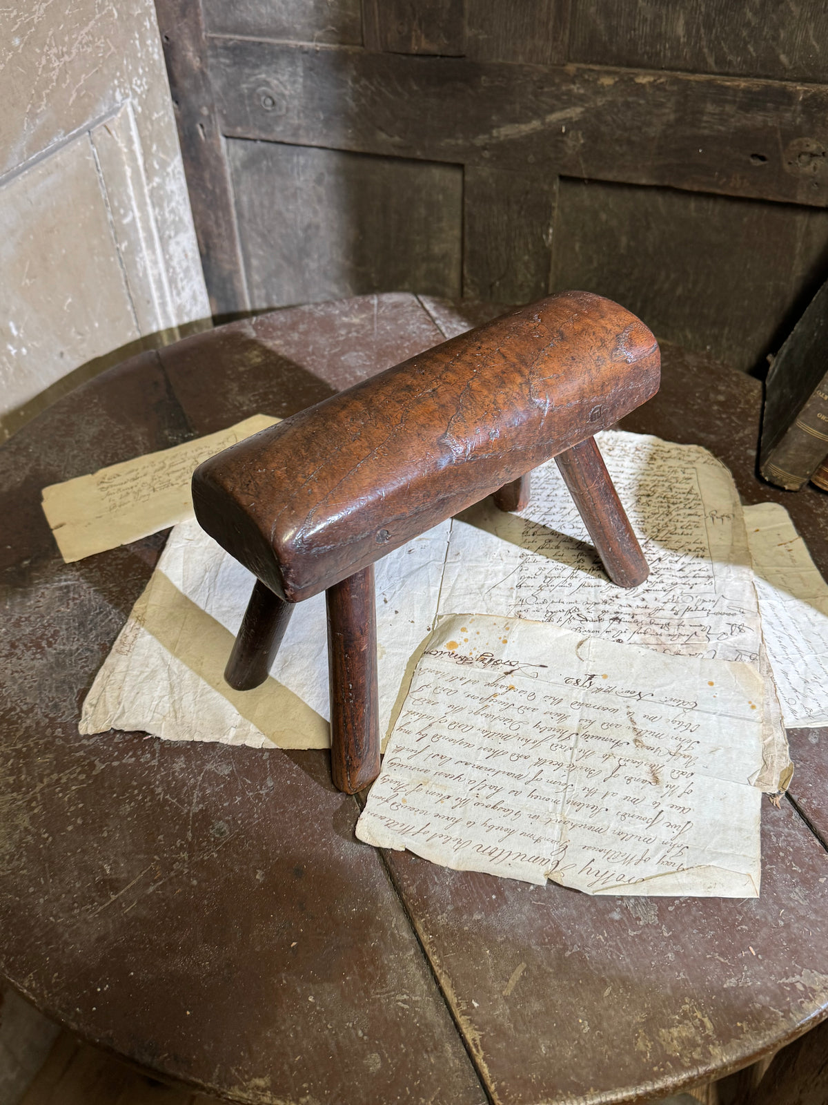 An unusual diminutive vernacular stool with sculpted rounded seat c.1800