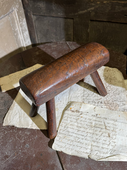 An unusual diminutive vernacular stool with sculpted rounded seat c.1800