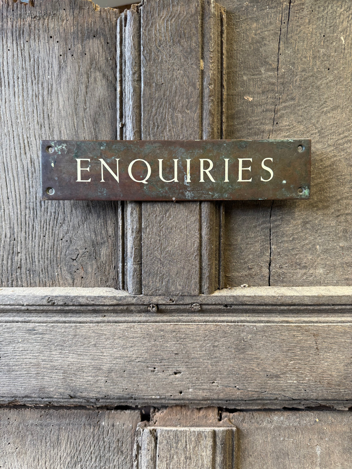 An early 20th century English 'Enquiries' brass door sign