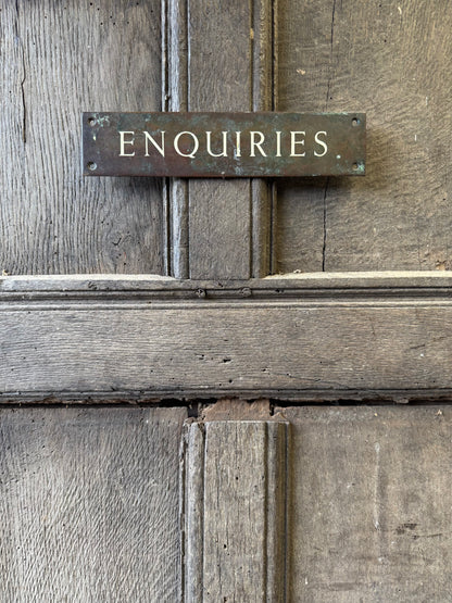 An early 20th century English 'Enquiries' brass door sign