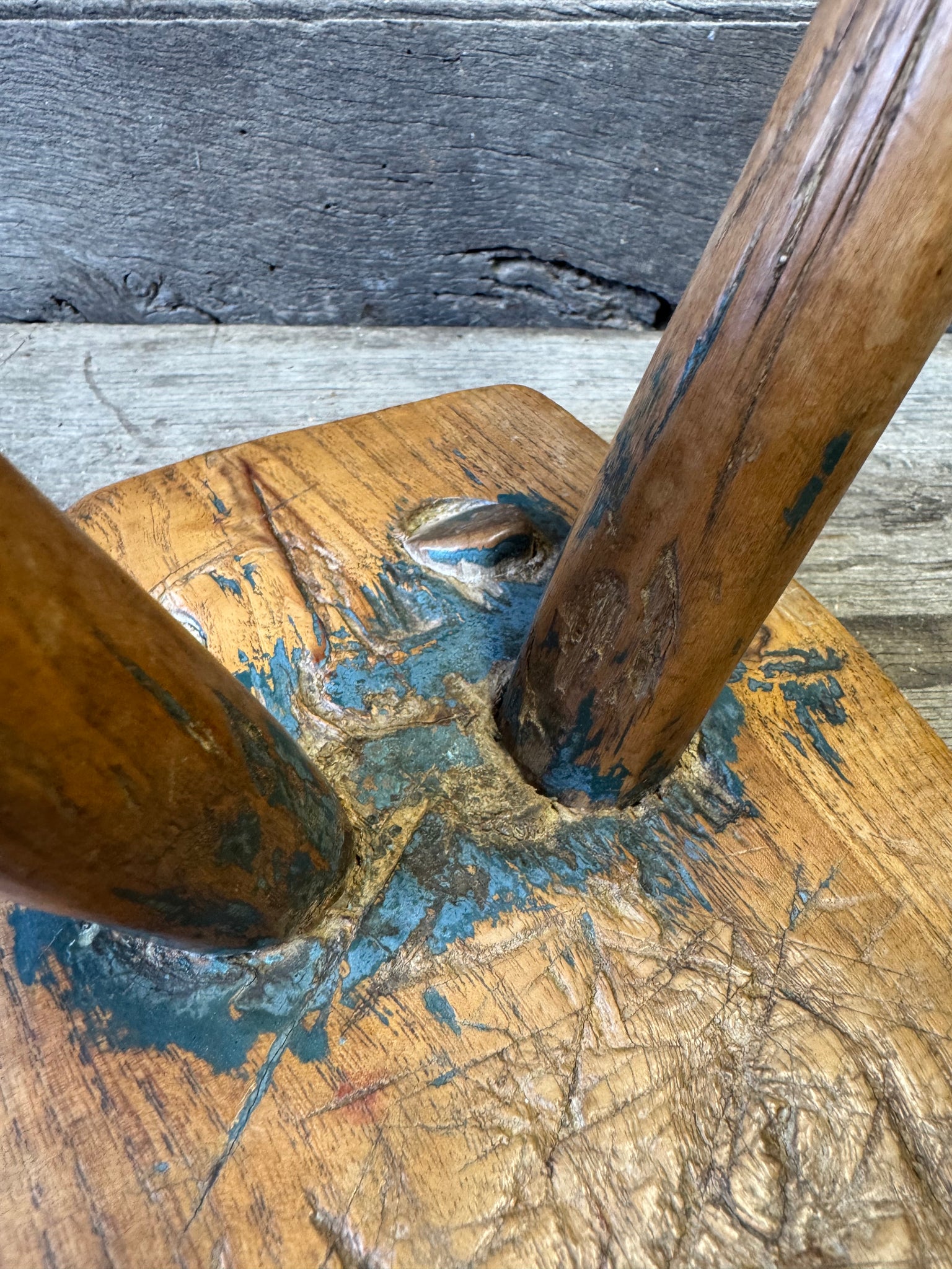 An 18th century elm slab top stool standing over three legs