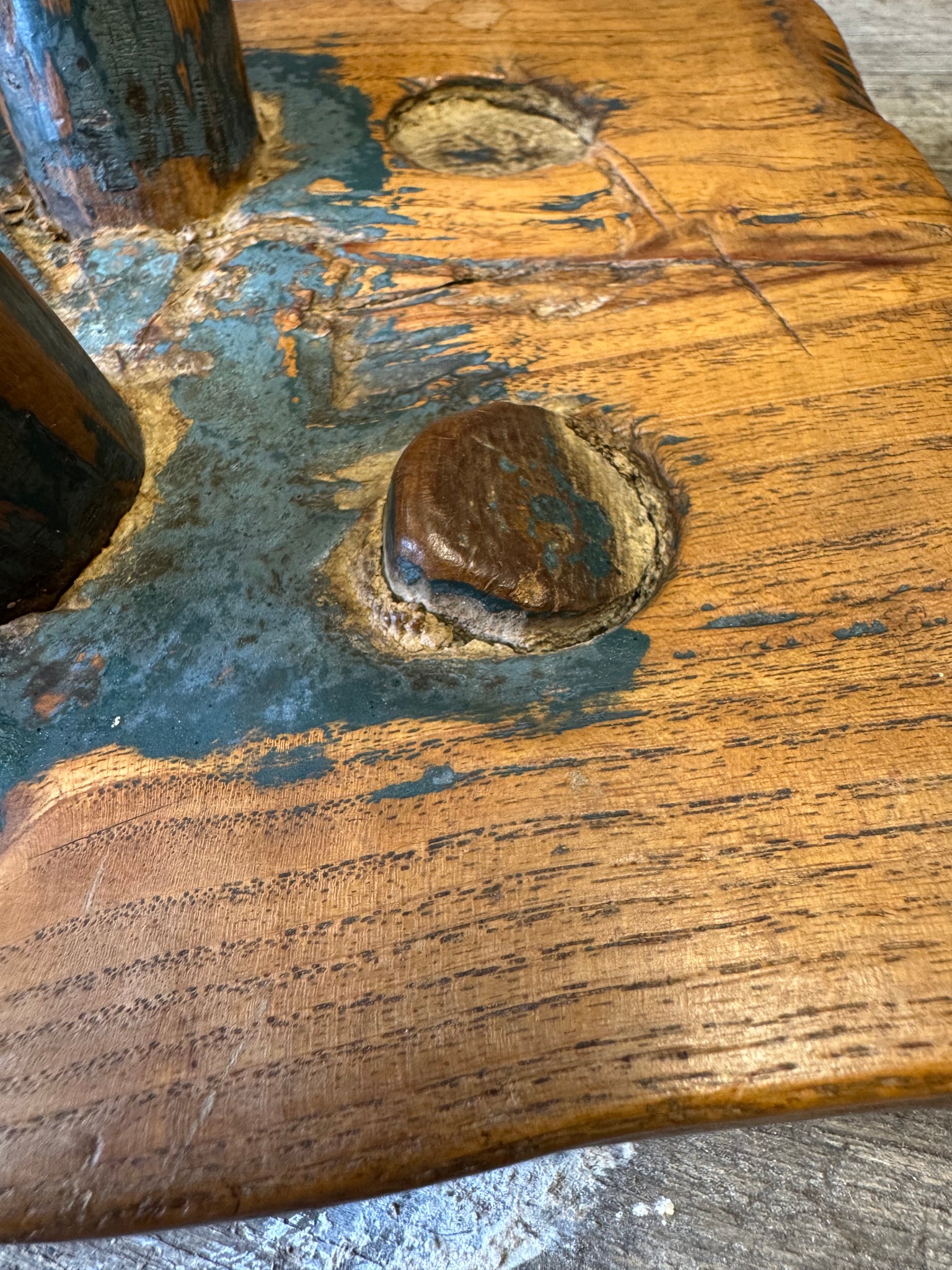 An 18th century elm slab top stool standing over three legs