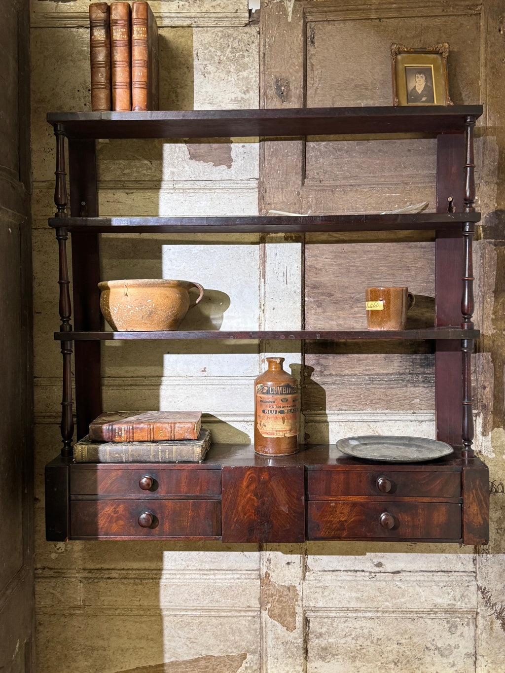A 19th century set of mahogany apothecary wall shelves with original labels to drawer interiors