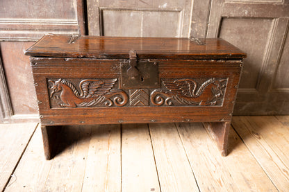 An  Elizabethan carved oak boarded chest with winged fantastic beasts, english, probably West Country, circa 1570–90