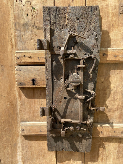 A large sculptural 17th century lock mounted on an oak board