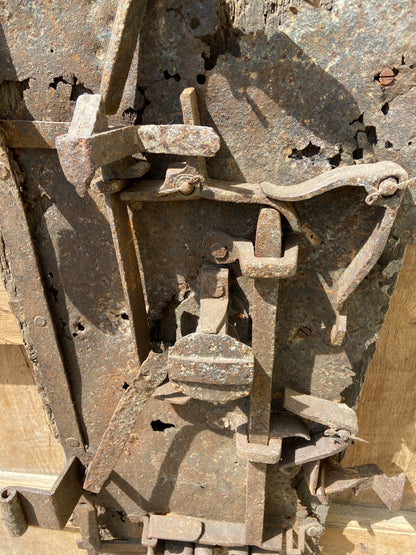 A large sculptural 17th century lock mounted on an oak board