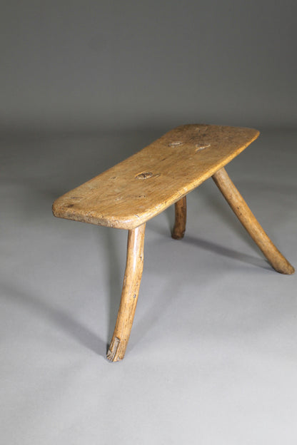 A fine example of a primitive early 19th c three legged sycamore stool