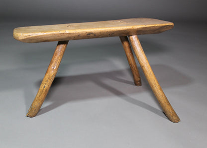 A fine example of a primitive early 19th c three legged sycamore stool