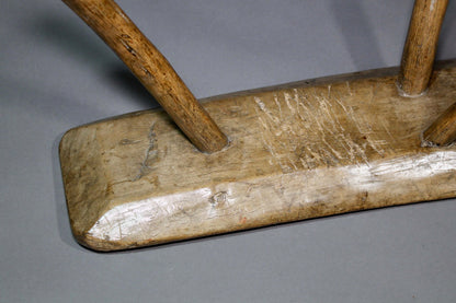 A fine example of a primitive early 19th c three legged sycamore stool