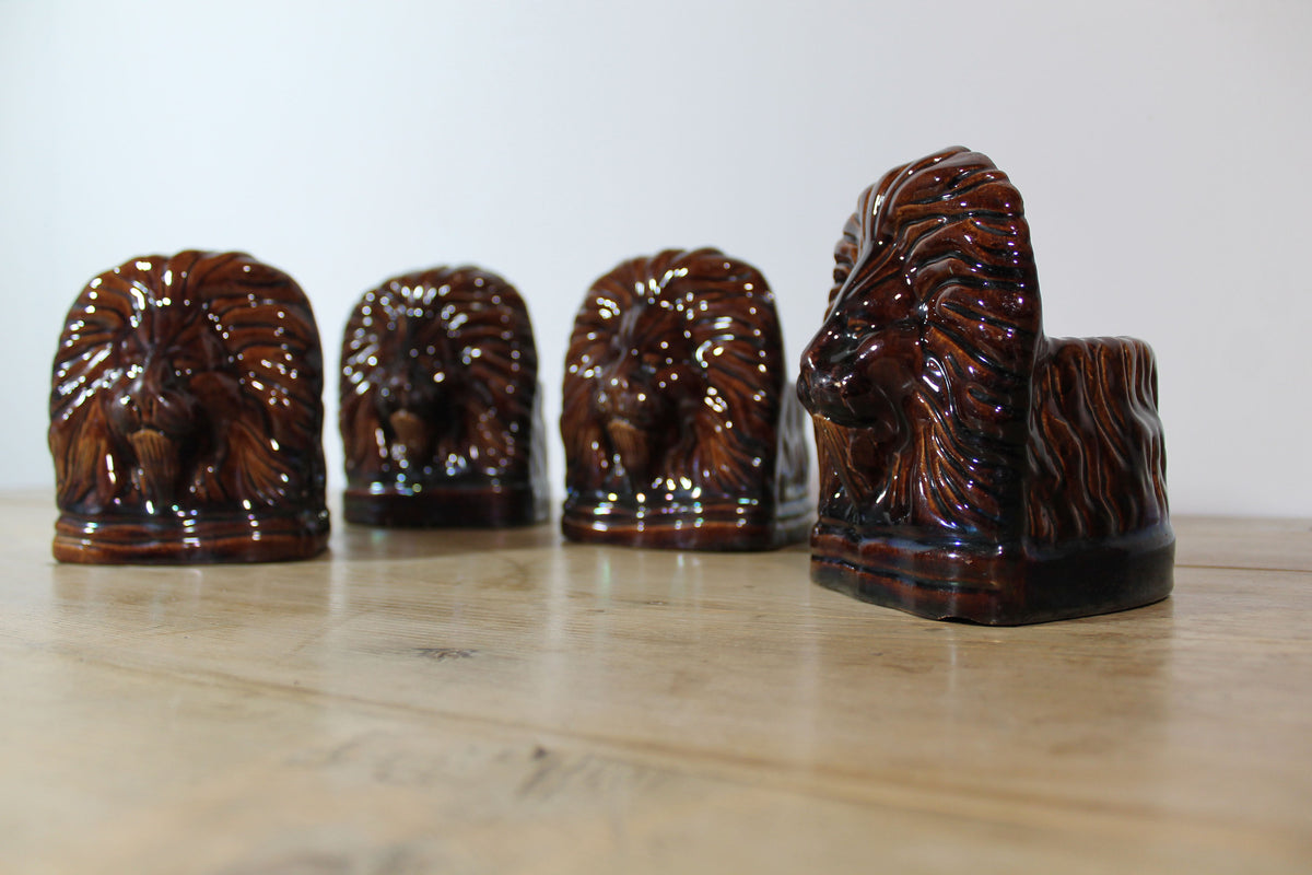 Set of four treacle glazed sash window stops in the form of lions c. 1870