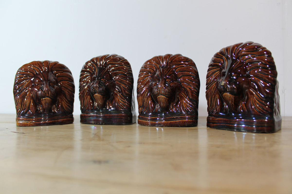 Set of four treacle glazed sash window stops in the form of lions c. 1870