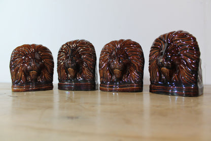 Set of four treacle glazed sash window stops in the form of lions c. 1870