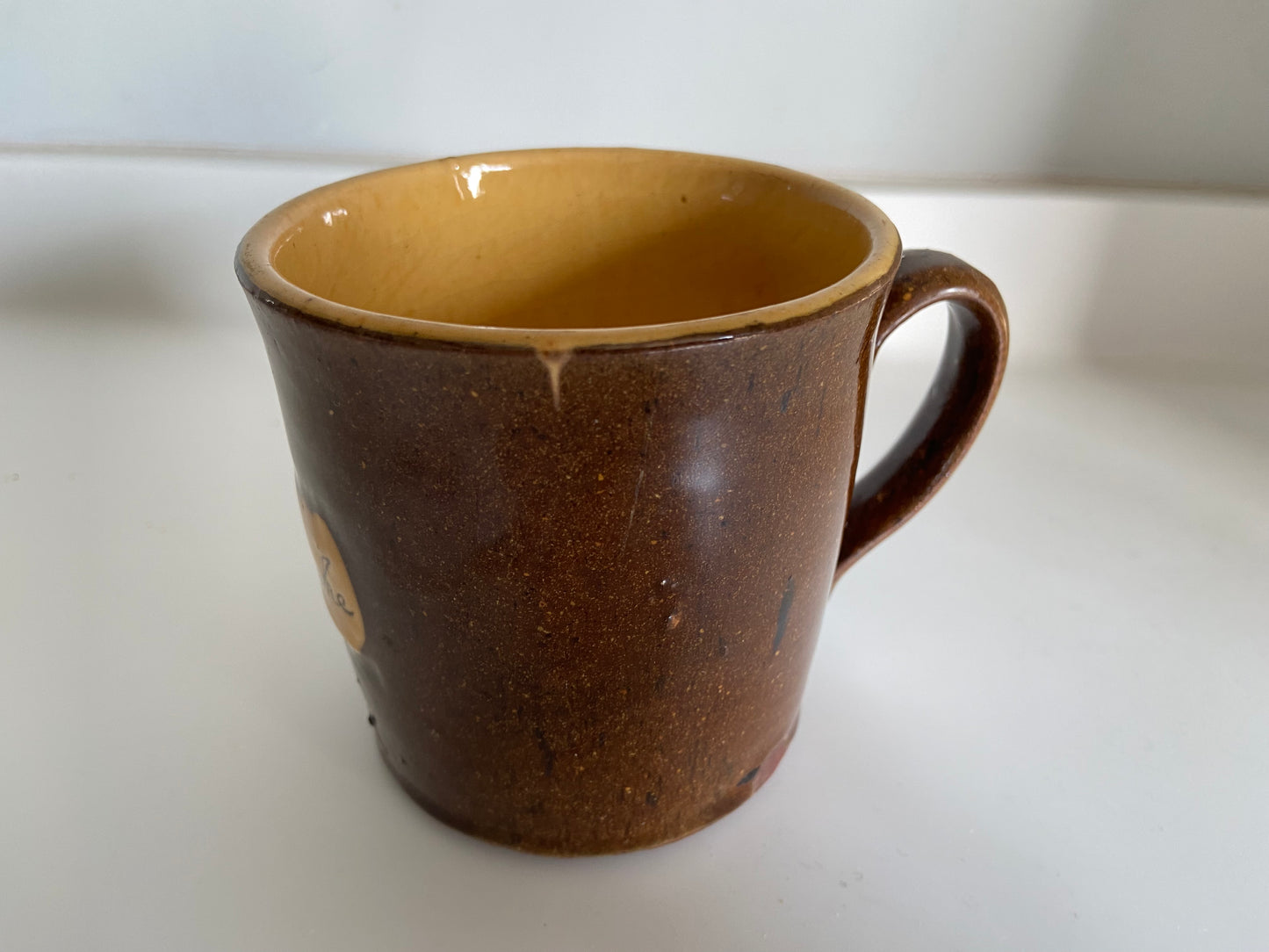 A slipware mug by Isaac Button of Soil Hill, Halifax